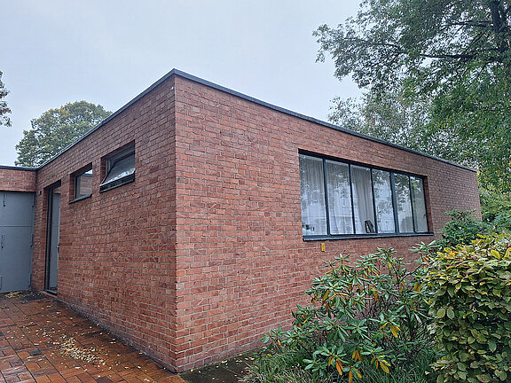 Exterior view of the low-rise building made of red bricks. Designed by the architect Mies van der Rohe.