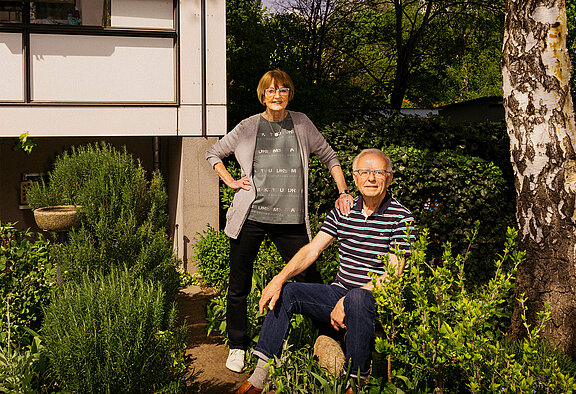 Ein Mann und eine Frau stehen in ihrem Garten.