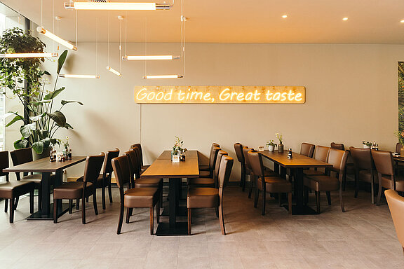 Interior view of the restaurants with tables and chairs.