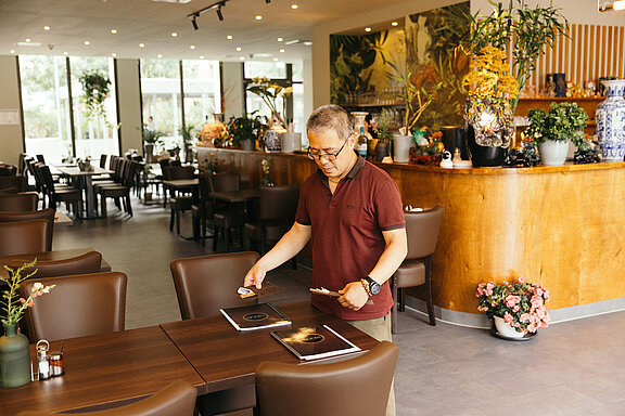 Chủ nhà hàng đang dọn bàn. 