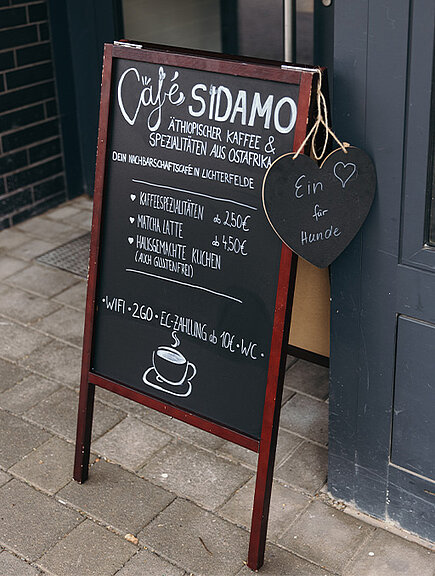 Ein Foto des Außen-Schildes vom Café Sidamo mit aktuellem Menü