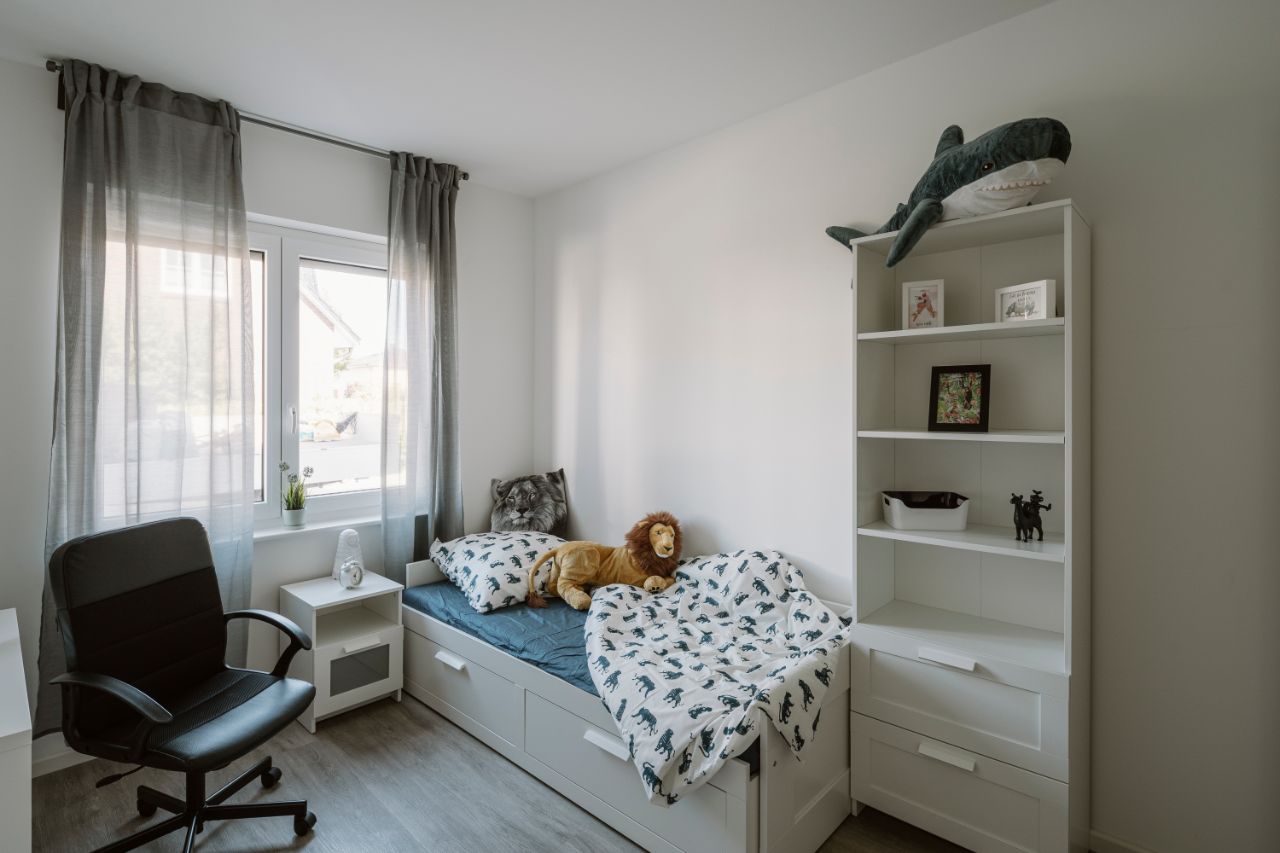 Bild – Eingerichtetes Kinderzimmer mit Bett, Schreibtisch und Schrank