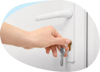 Eine Hand steckt einen Schlüsselbund in ein Türschloss.