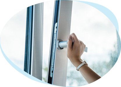 Eine Hand öffnet oder schließt ein Fenster. Das Fenster ist auf Kippe. 