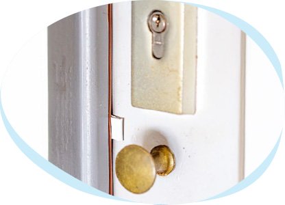 Ein Stück Plastik steckt an einer verschlossenen Haustür zwischen Türrahmen und Haustür. 