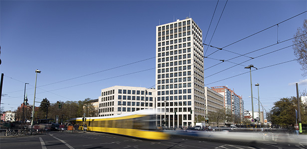 Stefan-Heym-Platz mit Blick auf den neuen Büroturm, im Vordergrund eine Vrobeifahrende Straßenbahn, © HOWOGE Lydia Hesse